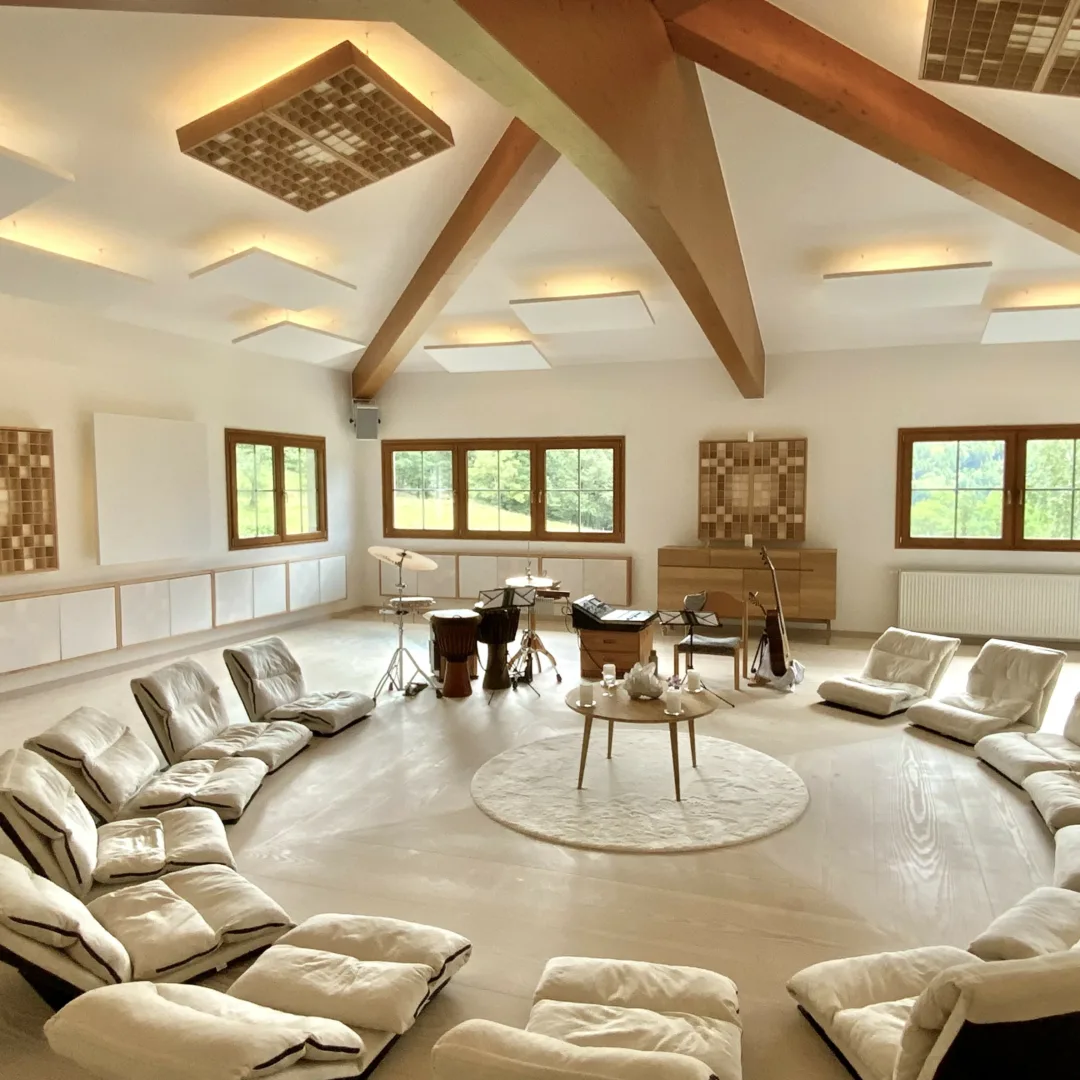 The Casa with musical instruments and floor chairs arranged in a circle around a round table with a crystal.