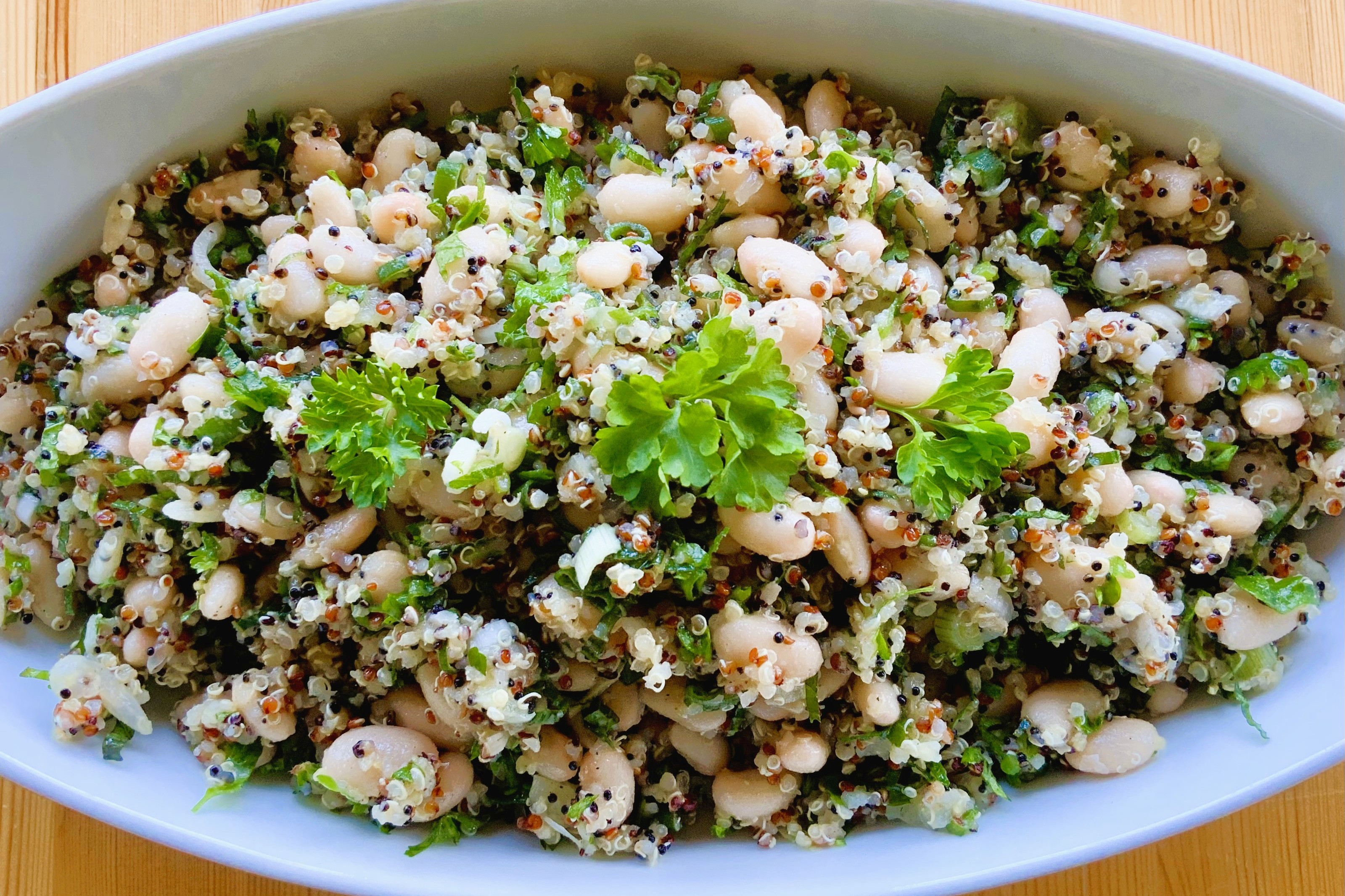 Spicy and herbaceous sprouted quinoa salad with beans and fresh herbs.